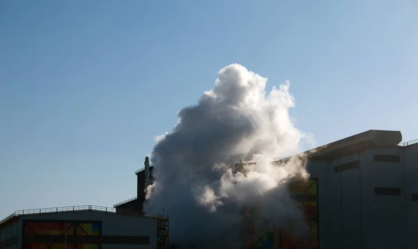 Smoke from chemical factory chimney on cloudy sky background. Ecology theme.