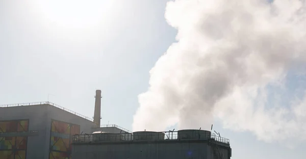 Smoke from chemical factory chimney on cloudy sky background. Ecology theme.