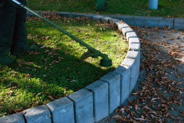 Parkta sonbahar çalışması. Bahçıvan kıştan önce çimleri biçer..