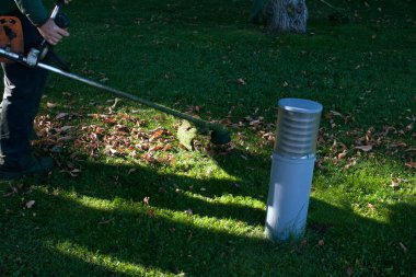 Parkta sonbahar çalışması. Bahçıvan kıştan önce çimleri biçer..