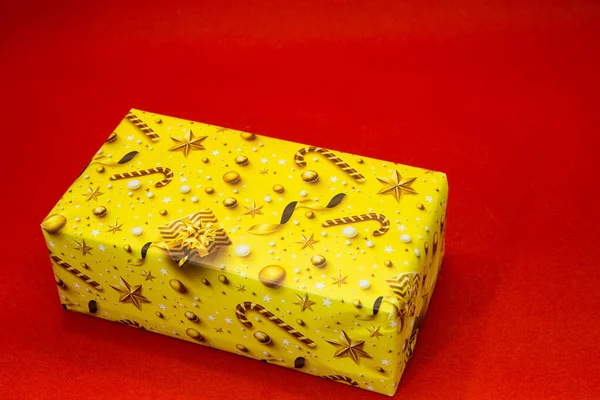 红色背景的圣诞黄色礼品盒 设计师用的空白 — 图库照片