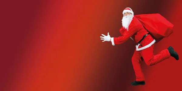 Święty Mikołaj Biegnie Dużą Czerwoną Torbą Prezentami Zbliżenie Czerwonym Tle — Zdjęcie stockowe