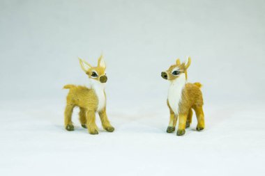 Kış konsepti Beyaz arka planda iki oyuncak geyik..