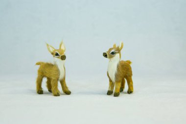 Kış konsepti Beyaz arka planda iki oyuncak geyik..