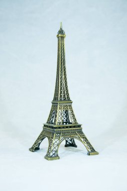 Beyaz arka planda izole edilmiş Eyfel kulesinin küçük bronz bir kopyası. Paris 'in asıl eğlencesi.