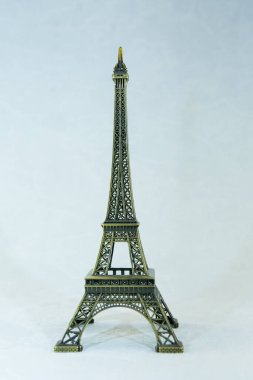 Beyaz arka planda izole edilmiş Eyfel kulesinin küçük bronz bir kopyası. Paris 'in asıl eğlencesi.