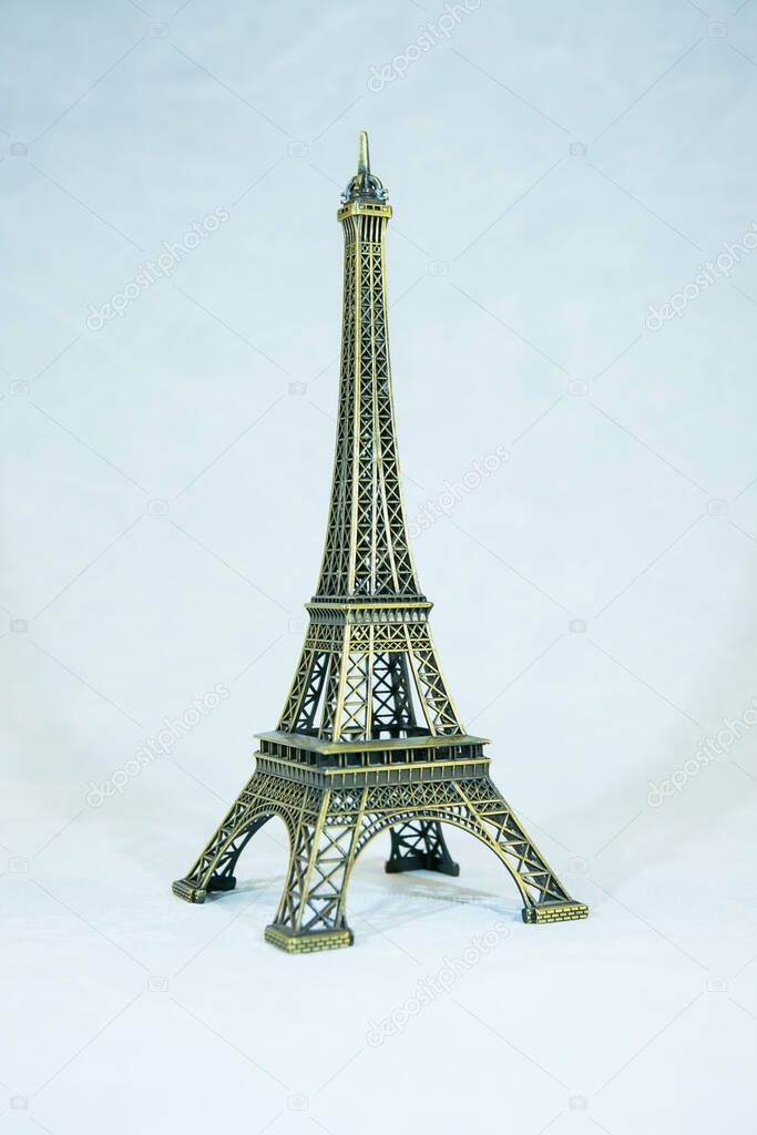 Small bronze copy of Eiffel tower figurine isolated on white background. The main attraction of Paris.