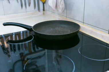 Yağlı ve sosisli omlet pişirme işlemi. Adam iki porsiyon hazırlıyor. Elektrikli ocağın üstünde tava..