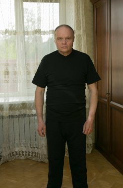 Sabah egzersizleri. Yaşlı bir adam evde jimnastik yapıyor. Karantina süresince tüm spor merkezleri kapalıdır..