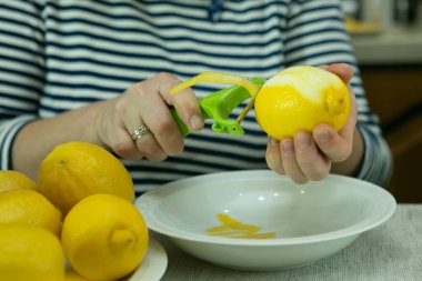 Evde limoncello limonata yapma süreci. Kadın limonlardan lezzeti alıyor..