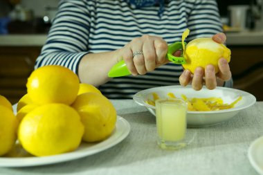 Evde limoncello limonata yapma süreci. Kadın limonlardan lezzeti alıyor..