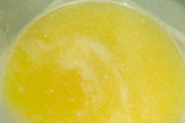 Limon arka planı. Konteynırda taze sıkılmış limon suyu.