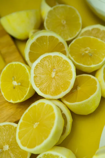 Fresh ripe lemons. A background of a large number of lemons, cut in half, without zest, lying on the table.
