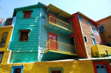 Buenos Aires, Arjantin - 01 / 07 / 2012: La Boca bölgesi. Çürük cepheler farklı renklerle boyanır ve pencere ve kapı çerçeveleri gümüşi bir gökyüzünün altında farklı renklerde boyanır..
