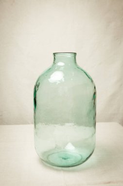 10 litre hacmi olan büyük boş bir cam şişe. Sıvı depolama, alkol ve koruma kapasitesi.