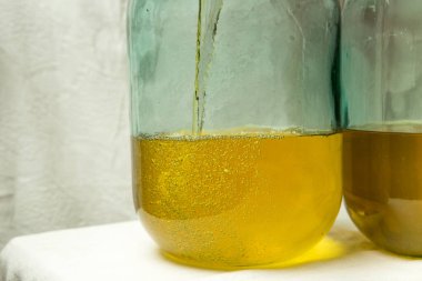 Evde limoncello limonata yapma süreci. İki on litrelik şişeyi limon suyuyla doldurmak..