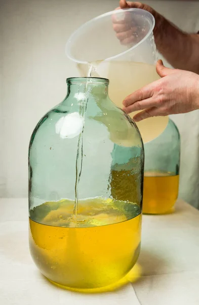 리몬첼로 리큐어를 집에서 만드는 남자가 레몬제스 알코올에 시럽을 리터짜리 유리병에 — 스톡 사진
