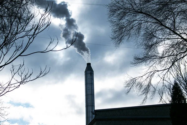 Smoke from chemical factory chimney on cloudy sky background. Ecology theme.