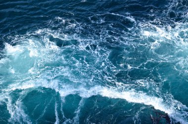 Soyut arkaplan. Deniz suyunun dalgaları su altı sivri kayalarla birleşerek girdapları oluşturur. Norveç 'in Bodo kentindeki girdaplar. Norveç