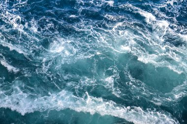 Soyut arkaplan. Deniz suyunun dalgaları su altı sivri kayalarla birleşerek girdapları oluşturur. Norveç 'in Bodo kentindeki girdaplar. Norveç