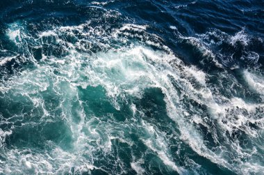 Soyut arkaplan. Deniz suyunun dalgaları su altı sivri kayalarla birleşerek girdapları oluşturur. Norveç 'in Bodo kentindeki girdaplar. Norveç