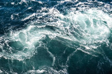 Soyut arkaplan. Deniz suyunun dalgaları su altı sivri kayalarla birleşerek girdapları oluşturur. Norveç 'in Bodo kentindeki girdaplar. Norveç