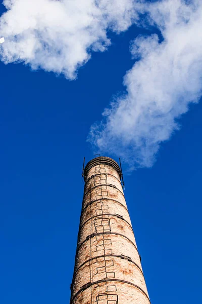 Smoke from chemical factory chimney on cloudy sky background. Ecology theme.