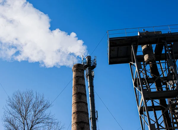 Smoke from chemical factory chimney on cloudy sky background. Ecology theme.