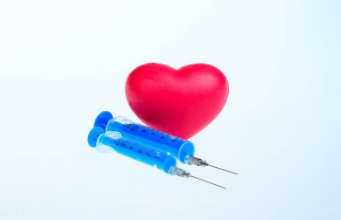 Kırmızı kalp ve beyaz arka planda şırıngalar. İzole et. Sağlıklı yaşam tarzı kavramı. Kardiyoloji.