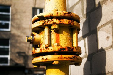 Kapakçığı açık sarı gaz borusu çok katlı bir binanın ön cephesi boyunca uzanıyor. Ev iç kullanım için benzine bağlı.