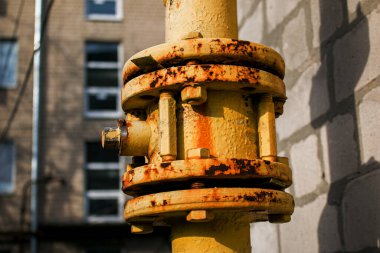 Kapakçığı açık sarı gaz borusu çok katlı bir binanın ön cephesi boyunca uzanıyor. Ev iç kullanım için benzine bağlı.