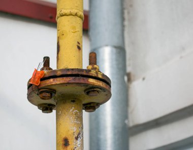 Bağlayıcılı sarı bir gaz borusu çok katlı bir binanın ön cephesi boyunca uzanıyor. Ev iç kullanım için gaza bağlıdır.
