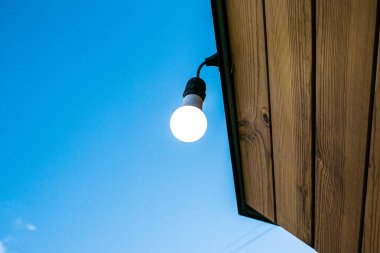 Gündüz vakti sokak ışıklarının ışıklarıyla yakın çekim görüntüsü geliyor. Elektrik israfı kavramı.