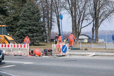 Dnepropetrovsk, Ukrayna - 03.16.2021: Yoldaki su giderici tamir çalışması. Kentin belediye hizmetleri kazayı ortadan kaldırdı.