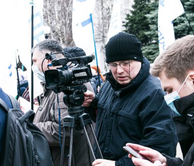 Dnepropetrovsk, Ukrayna - 03.19.2021: Gazeteciler karantina uygulamasını protesto etmek için girişimcilerin mitinginde çalışıyorlar.