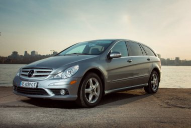 Dnepropetrovsk, Ukrayna - 03.15.2021: Mercedes-Benz R 350 otomobili gün batımında şehrin ufuk çizgisine karşı sette.