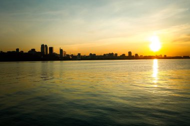 Gün batımında şehir seti. Dnepr Nehri Avrupa 'nın en uzun dördüncü nehri. Suyun dalgaları üzerinde parıldayan güneş ışığı.