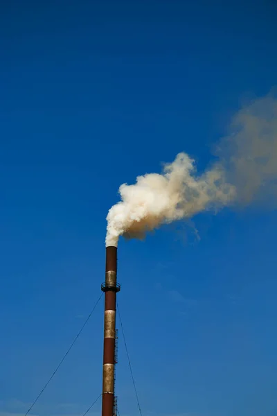 Smoke from chemical factory chimney on cloudy sky background. Ecology theme.