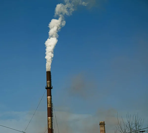 Smoke from chemical factory chimney on cloudy sky background. Ecology theme.