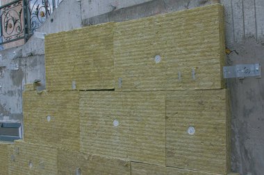 Merdiven duvarına dışarıdan mineral yün paneller ile termal yalıtım malzemesi yerleştirilmiş. Dış yapıların onarımı ve yalıtımı kavramı.