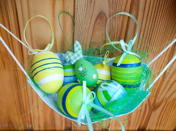 Spring holiday concept. Holidays amid the coronavirus pandemic. Easter decorations are folded into a medical mask, like a basket. Photo on a wooden background.