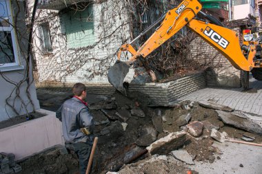 Dnepropetrovsk, Ukrayna - 03.26.2021: Su işçileri eski bir rögar kapağını açıp eski paslı boruları yenileriyle değiştirdiler.