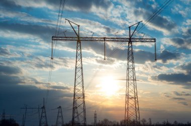 Akşamki elektrik iletim kulesinin silueti. Bir enerji santralinden bir şehre güç aktarımı.