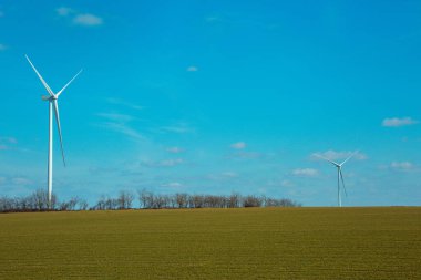 Buğday tarlasında rüzgar türbinleri. Yel değirmenleri alternatif enerji kaynaklarından biridir..