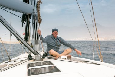 Yelkenli bir yatta bir adam. Kalima, Tenerife 'yi kapladı. Yat şoförü fırtına biter bitmez denize açıldı..