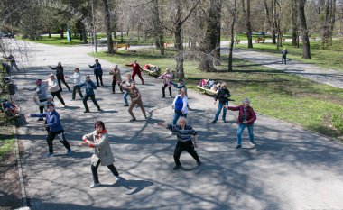 Dnepropetrovsk, Ukrayna - 04.22.2021: Bir parkta sağlık ve jimnastik kursu alan bir grup son sınıf öğrencisi.