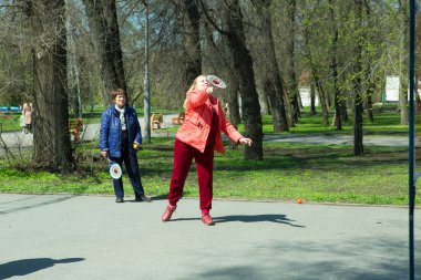Dnepropetrovsk, Ukrayna - 04.22.2021: Parkta sağlık iyileştirici jimnastik yapan bir grup yaşlı insan. Yaşlı adamlar minitenis oynar..