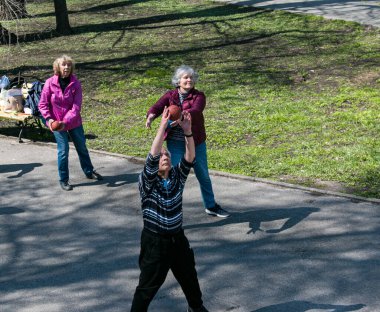 Dnepropetrovsk, Ukrayna - 04.22.2021: Parkta sağlık ve spor yapan bir grup yaşlı insan. Yaşlı insanlar bir topla egzersiz yaparlar..