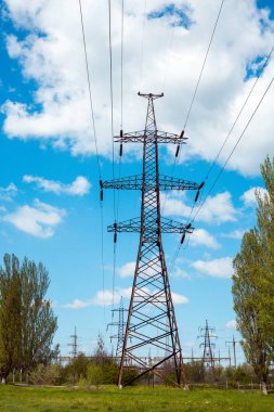 Mavi gökyüzüne karşı bir elektrik direğinin silueti. Elektrik santralinden şehire elektrik aktarımı.