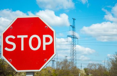 Yol tabelası. Seçici odaklanma. Arka plandaki elektrik hatlarında.